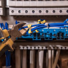 the Assembly of the electrical panel, electrician job, a robot with wires and circuit breakers, tools